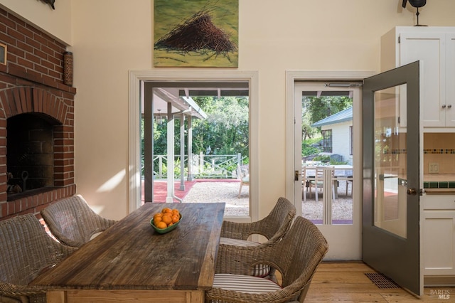 2480 Spring Mountain Rd, Saint Helena, CA 94574 - dining area with light wood-style floors and a brick fireplace