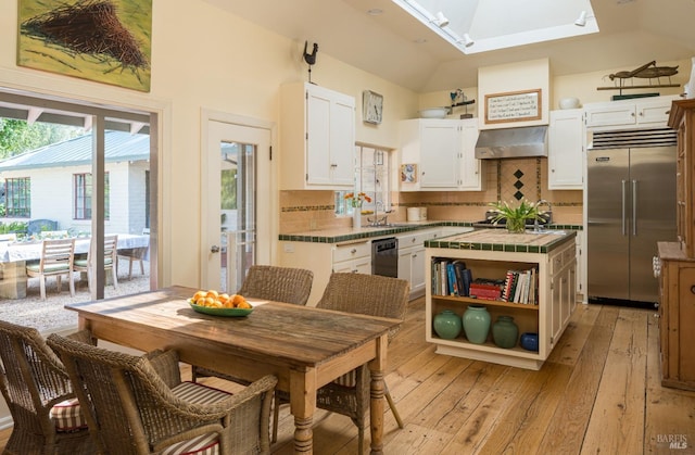 2480 Spring Mountain Rd, Saint Helena, CA 94574 - kitchen featuring appliances with stainless steel finishes, tile counters, light wood-type flooring, white cabinetry, and a skylight