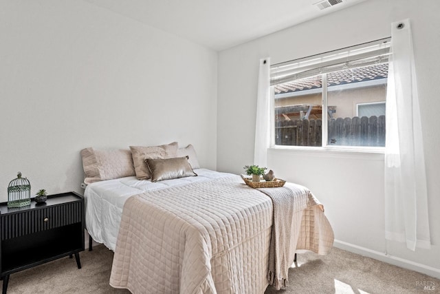 carpeted bedroom with visible vents and baseboards