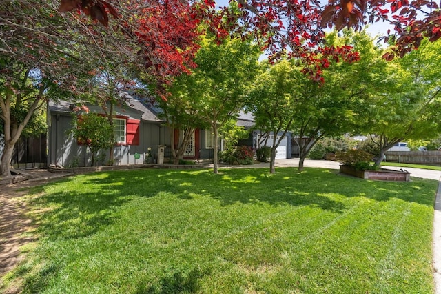 view of yard featuring fence and concrete driveway