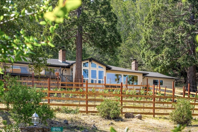 back of house with fence private yard and a chimney