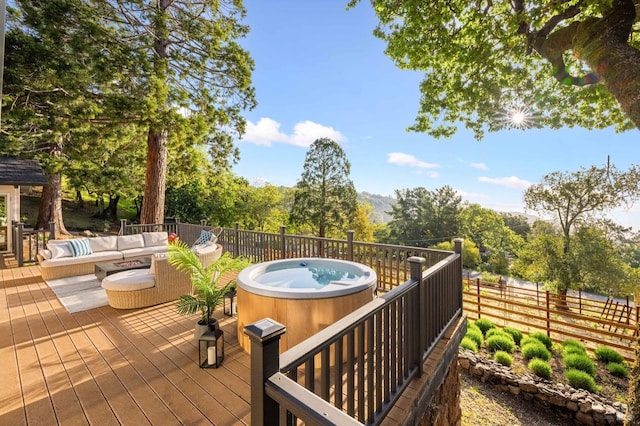 wooden deck with outdoor lounge area, fence, and a hot tub