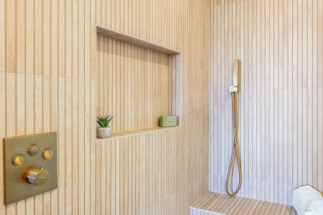 interior details featuring wallpapered walls and a tile shower