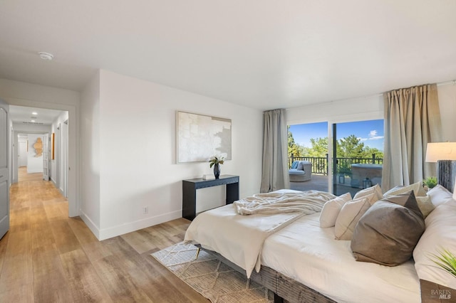 bedroom featuring light wood finished floors, access to exterior, and baseboards