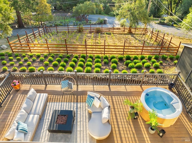 exterior space featuring a deck, fence, and a hot tub
