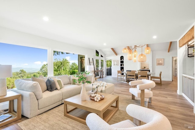 living area with recessed lighting, a chandelier, light wood-style floors, lofted ceiling with beams, and baseboards