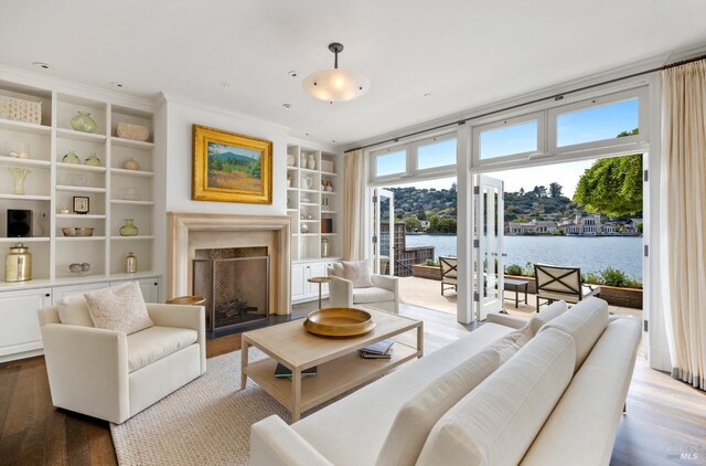72 Lagoon Rd, Belvedere, CA 94920 - living area featuring a fireplace, built in shelves, wood finished floors, and a water view