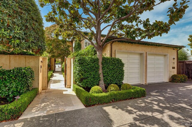 72 Lagoon Rd, Belvedere, CA 94920 - view of front of property featuring stucco siding, fence, and a garage
