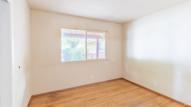 empty room featuring baseboards and light wood-style floors