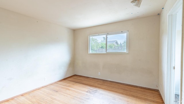 empty room with light wood finished floors and baseboards