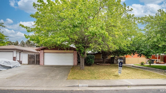 view of property hidden behind natural elements featuring driveway, an attached garage, a front yard, and brick siding