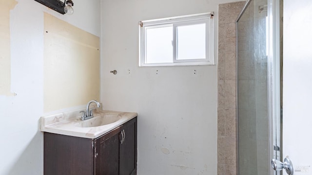 full bathroom featuring a tile shower and vanity