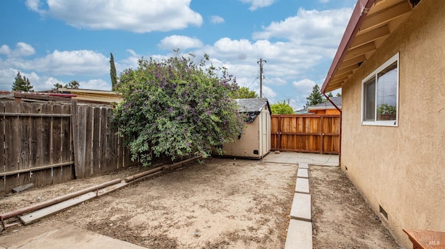 view of yard featuring a storage shed, an outdoor structure, and a fenced backyard