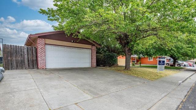 garage with fence and driveway