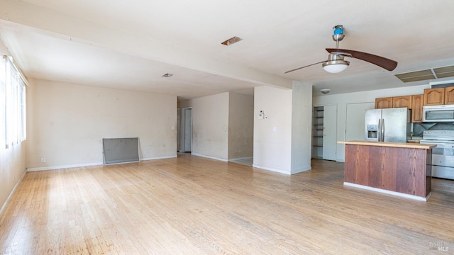 kitchen with light wood-style flooring, appliances with stainless steel finishes, baseboards, a center island, and a ceiling fan