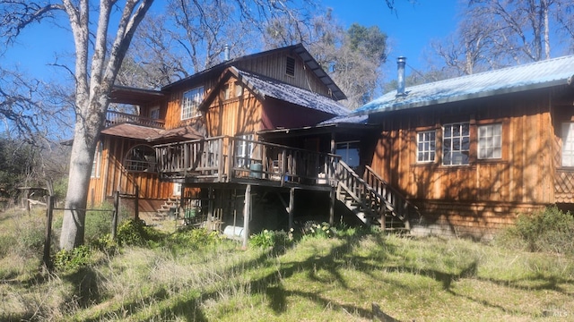back of property with stairway, a deck, and metal roof
