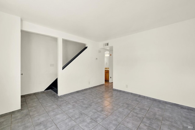 spare room with visible vents, stairs, and tile patterned flooring