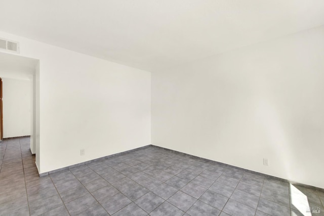 tiled spare room with visible vents