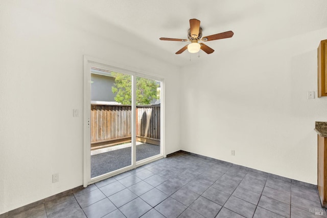 spare room with tile patterned flooring and a ceiling fan