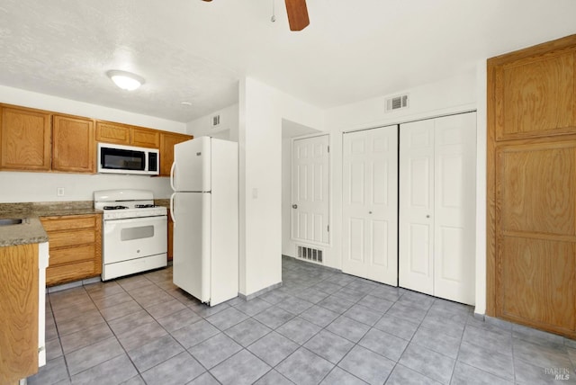 kitchen with visible vents, a ceiling fan, light tile patterned floors, and white appliances