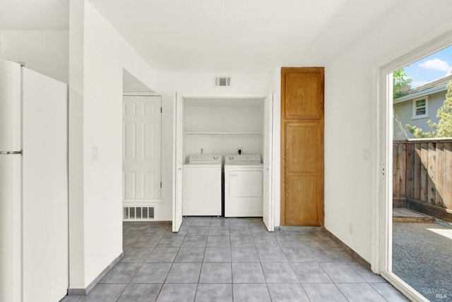 laundry area featuring laundry area, visible vents, built in shelves, and washer and clothes dryer