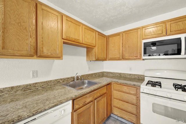 kitchen featuring white appliances and a sink