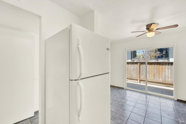 kitchen featuring baseboards, freestanding refrigerator, ceiling fan, and tile patterned floors