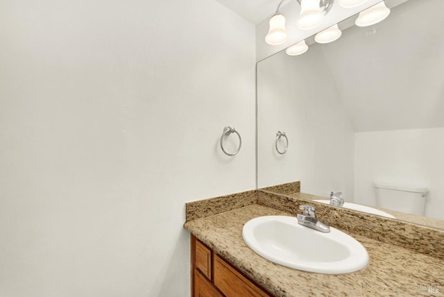 half bath featuring toilet, lofted ceiling, and vanity