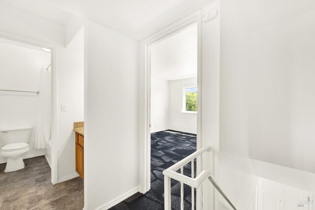 full bathroom with toilet, baseboards, shower / bath combo with shower curtain, and vanity