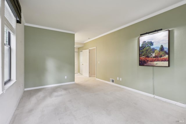 unfurnished room with baseboards, visible vents, carpet, and crown molding