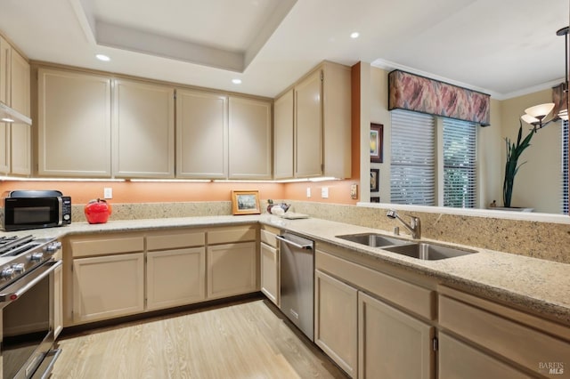 kitchen with a sink, stainless steel appliances, cream cabinetry, light wood-type flooring, and recessed lighting