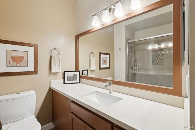 full bathroom featuring a stall shower, toilet, and vanity