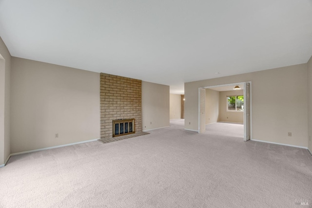 unfurnished living room with baseboards and light carpet