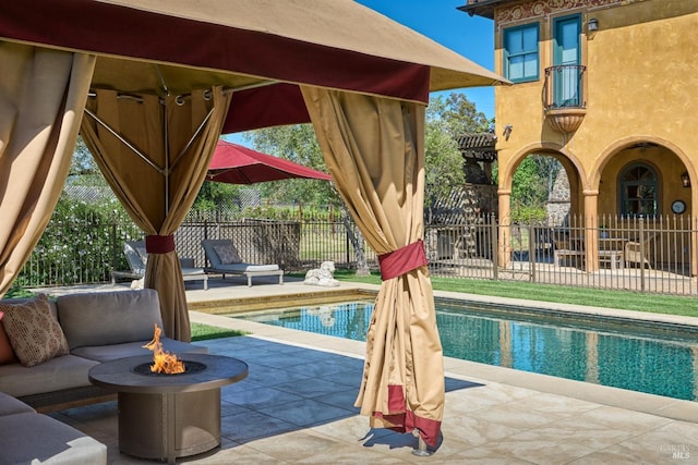 view of pool with fence, a fenced in pool, a patio area, and an outdoor fire pit