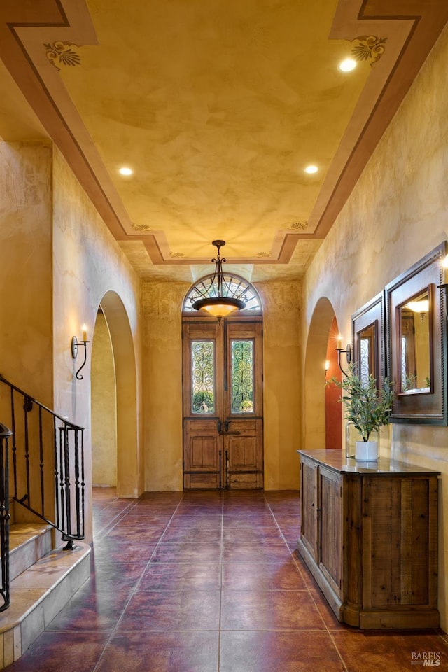 foyer entrance featuring arched walkways and stairs