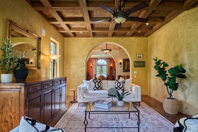 living room with ceiling fan, arched walkways, wood finished floors, beamed ceiling, and coffered ceiling