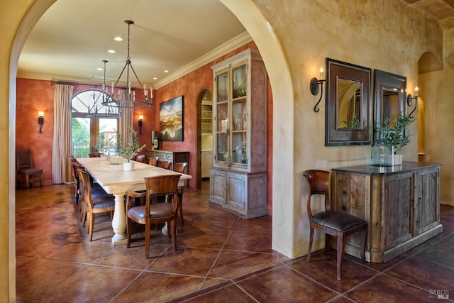 dining room featuring crown molding, arched walkways, built in features, and a chandelier