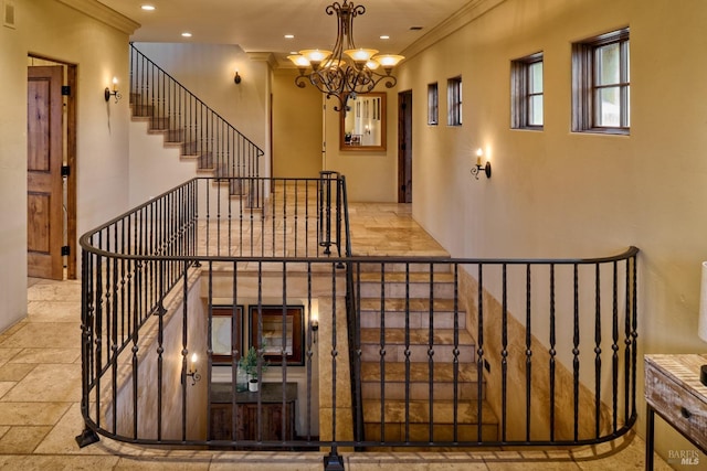 stairs with visible vents, ornamental molding, stone tile floors, recessed lighting, and a notable chandelier