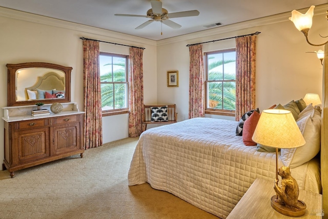 bedroom with crown molding, light carpet, and visible vents