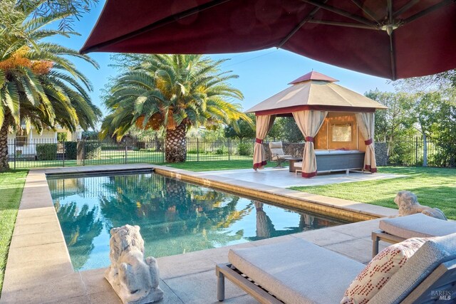 view of swimming pool featuring a lawn, fence, a fenced in pool, a patio area, and a gazebo