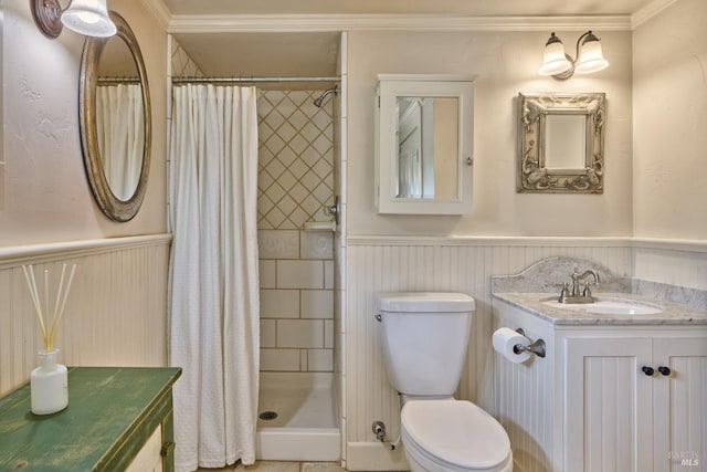 full bathroom with crown molding, vanity, toilet, a wainscoted wall, and a stall shower