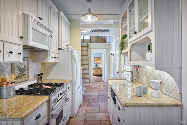 kitchen featuring white cabinets, open shelves, a sink, high end stove, and white microwave