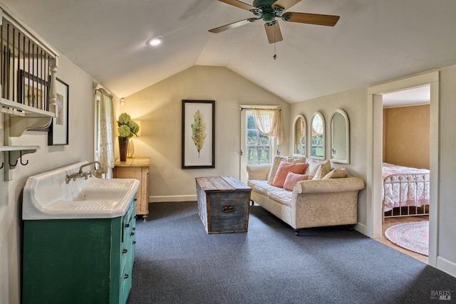 sitting room with a ceiling fan, baseboards, vaulted ceiling, and dark colored carpet