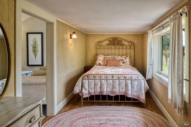 bedroom with baseboards and wood finished floors