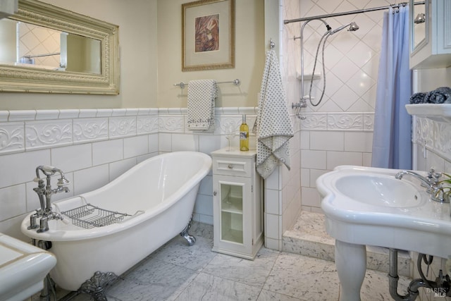 bathroom with wainscoting, a soaking tub, a tile shower, and tile walls