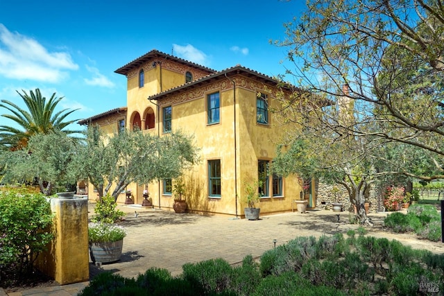 rear view of house featuring stucco siding