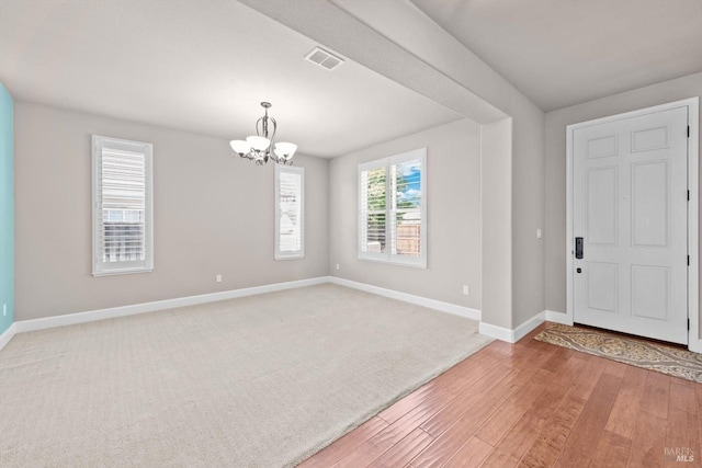 entrance foyer with baseboards, a chandelier, visible vents, and light wood-style flooring