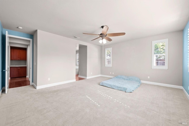 unfurnished bedroom featuring carpet flooring, baseboards, visible vents, and multiple windows