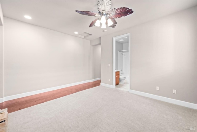 unfurnished bedroom with light colored carpet, connected bathroom, baseboards, and recessed lighting