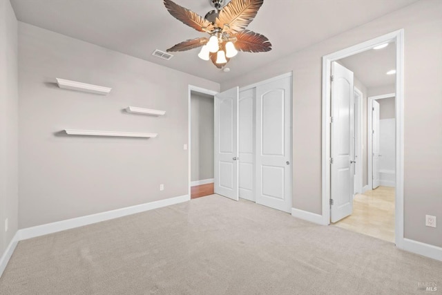 unfurnished bedroom featuring a ceiling fan, a closet, baseboards, visible vents, and carpet floors